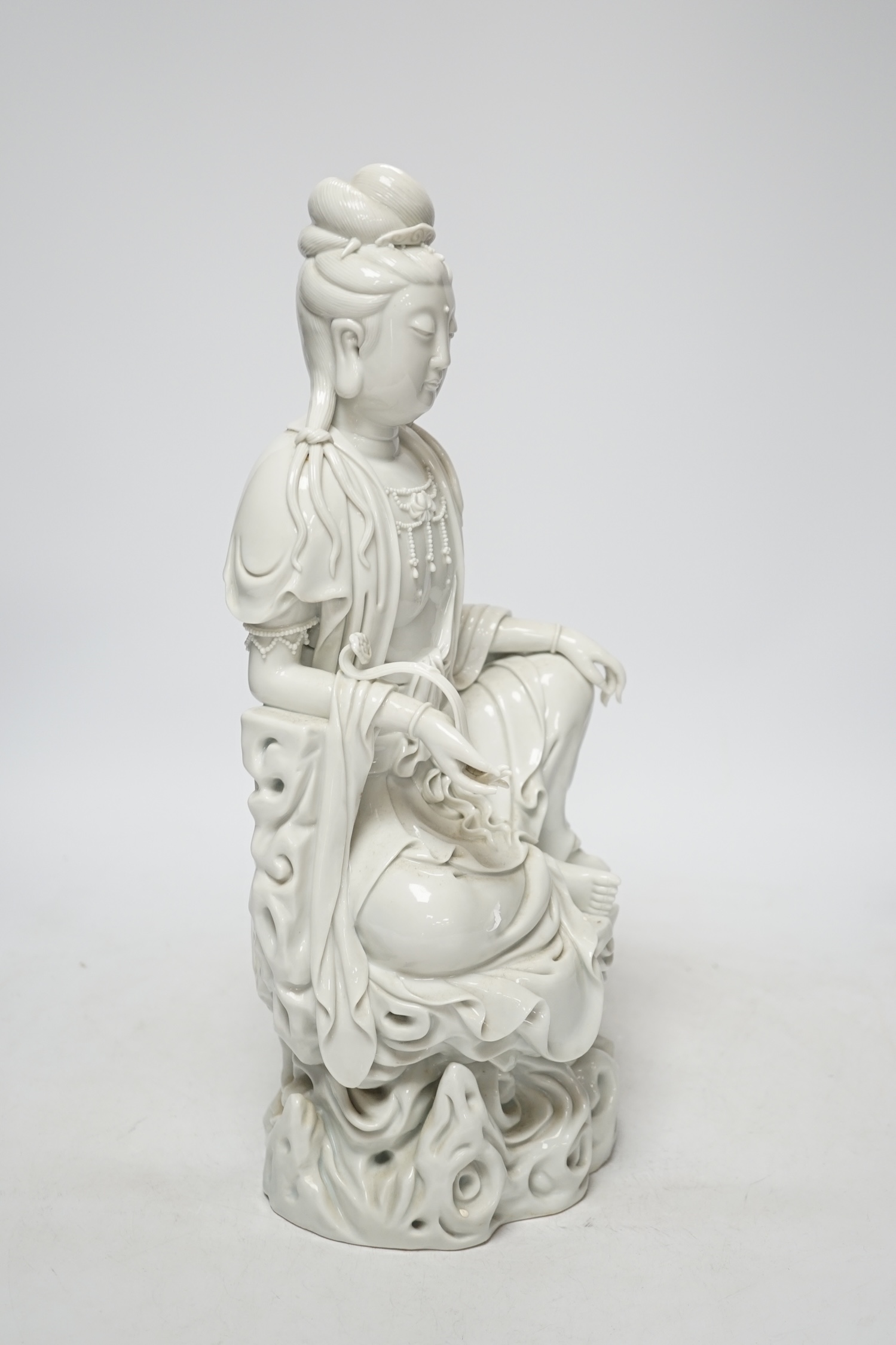 A late 19th / early 20th century Chinese blanc de Chine seated figure of Guanyin, impressed mark to back, 38cm